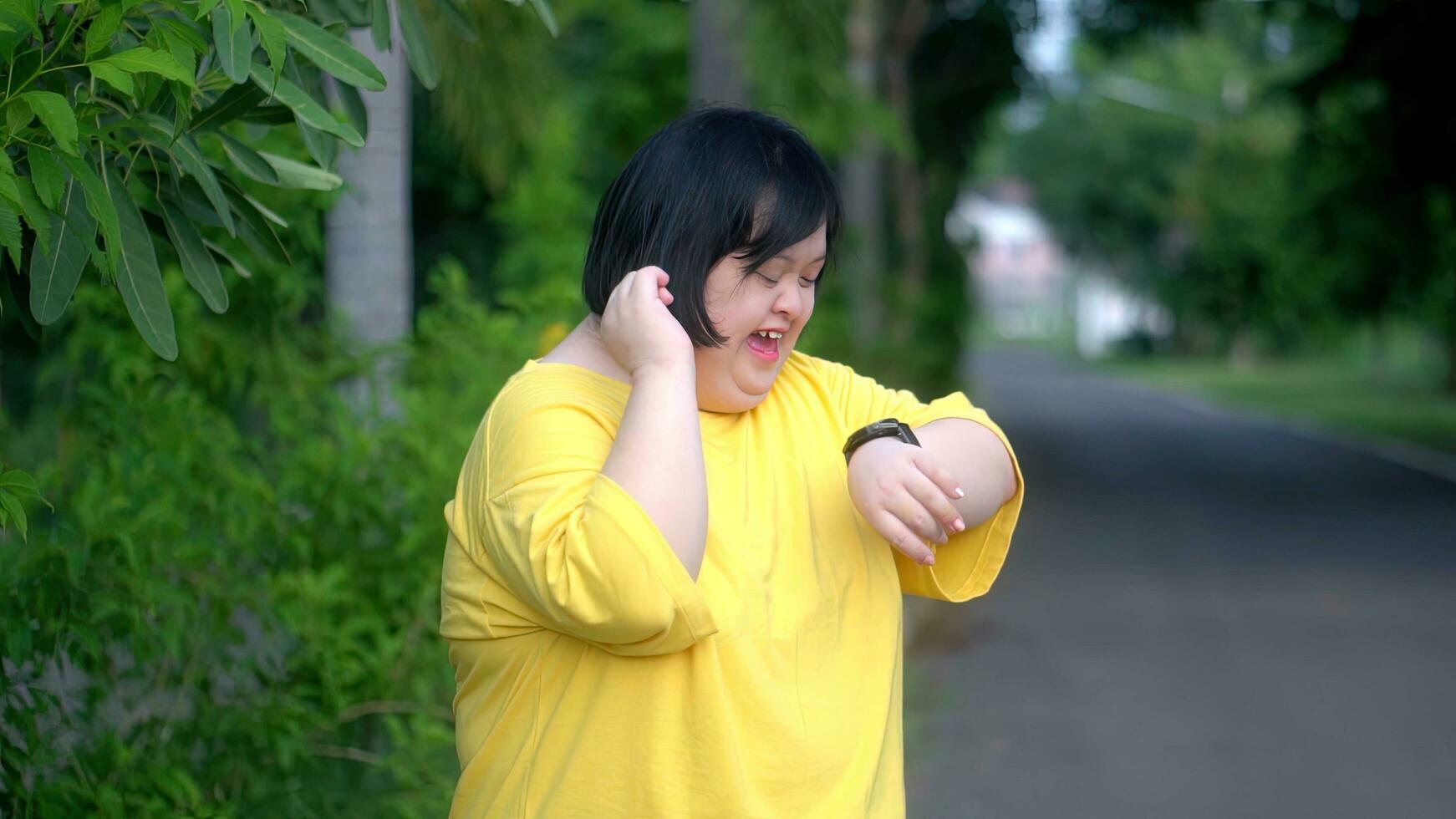 Looking at the clock, an Asian girl with Down syndrome rejoices.As I exercised in the park. photo