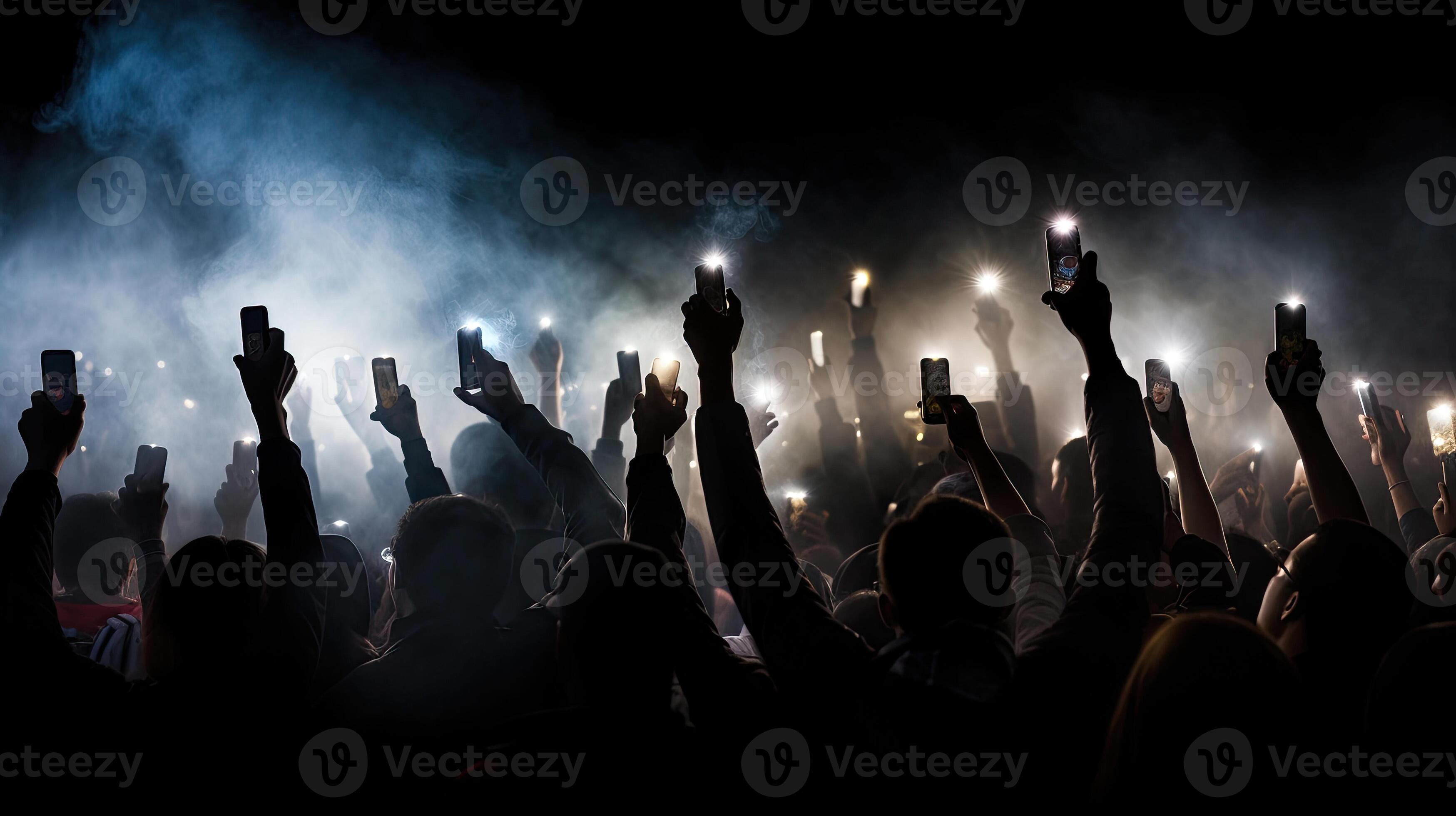 Group of people holding cigarette lighters and mobile phones at a