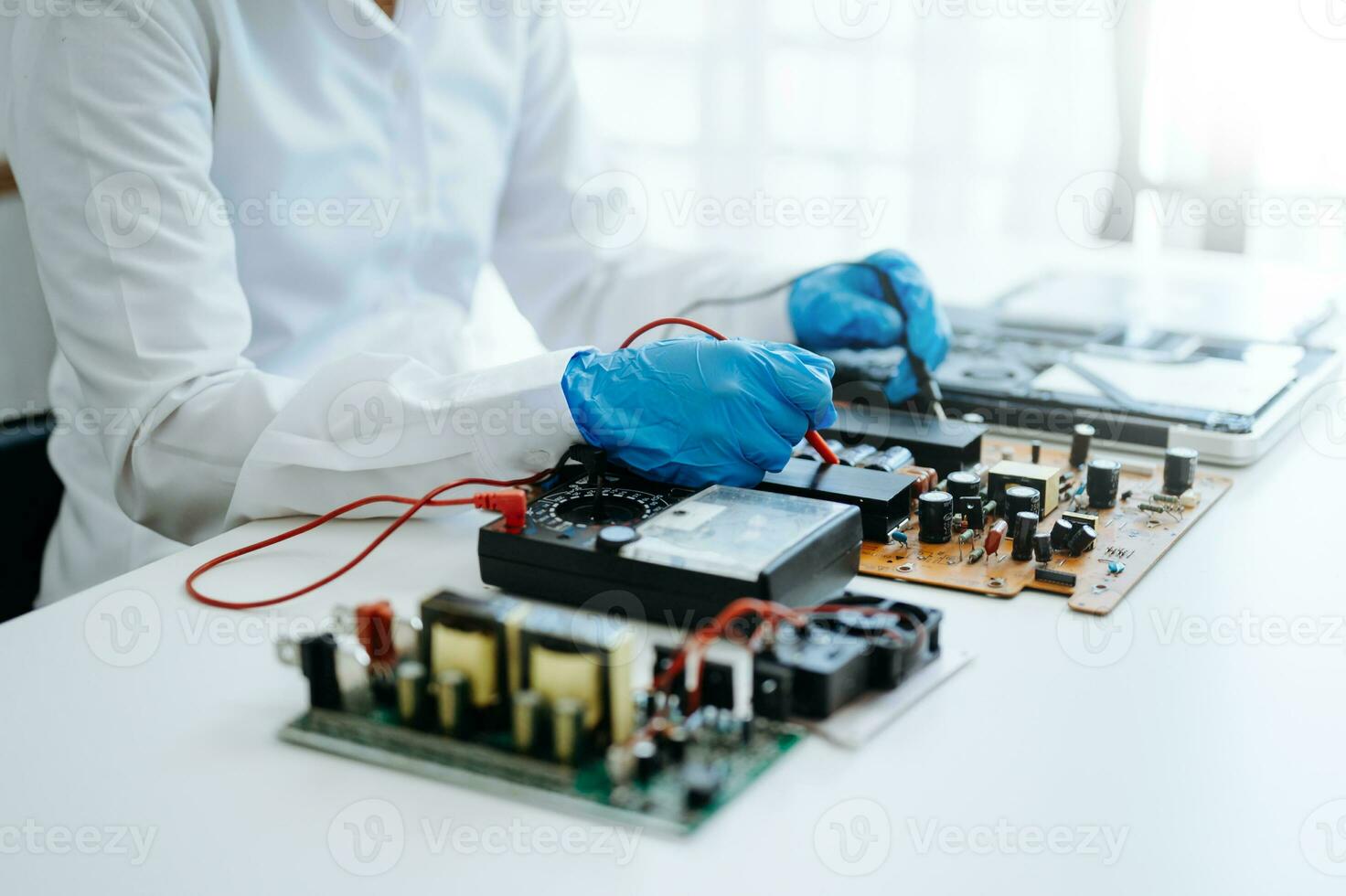 Electronics technician, electronic engineering electronic repair,electronics measuring and testing, repair and maintenance concepts.uses a voltage meter to check and upgrade photo