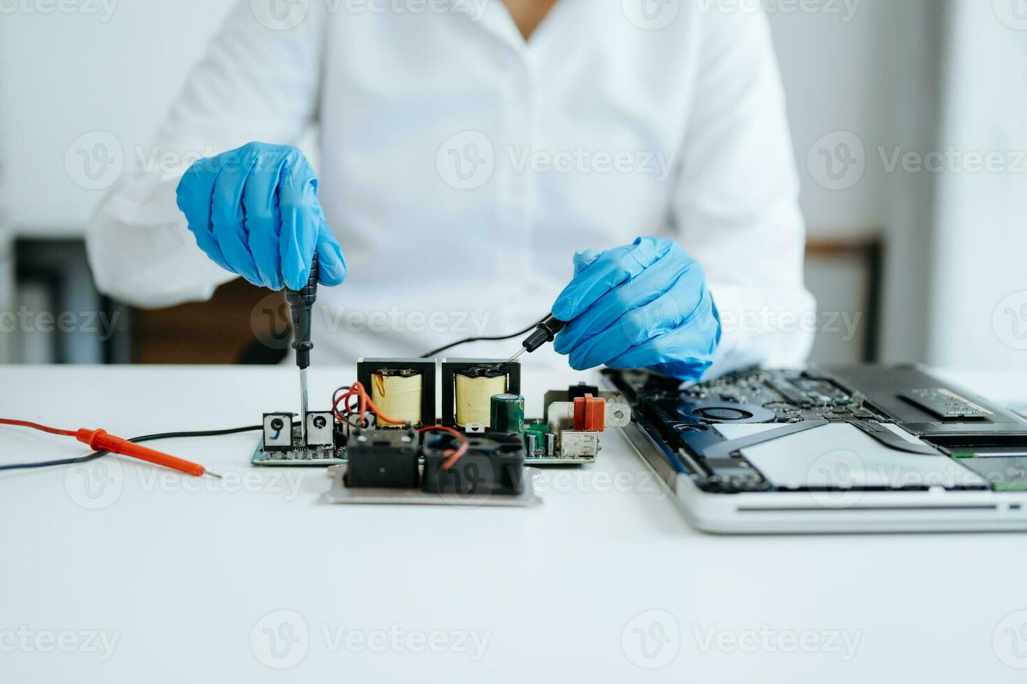 Electronics technician, electronic engineering electronic repair,electronics measuring and testing, repair and maintenance concepts.uses a voltage meter to check and upgrade photo