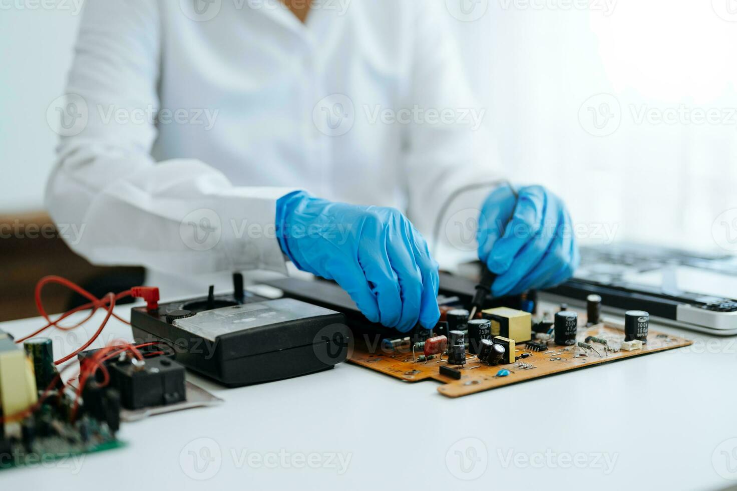 Electronics technician, electronic engineering electronic repair,electronics measuring and testing, repair and maintenance concepts.uses a voltage meter to check and upgrade photo