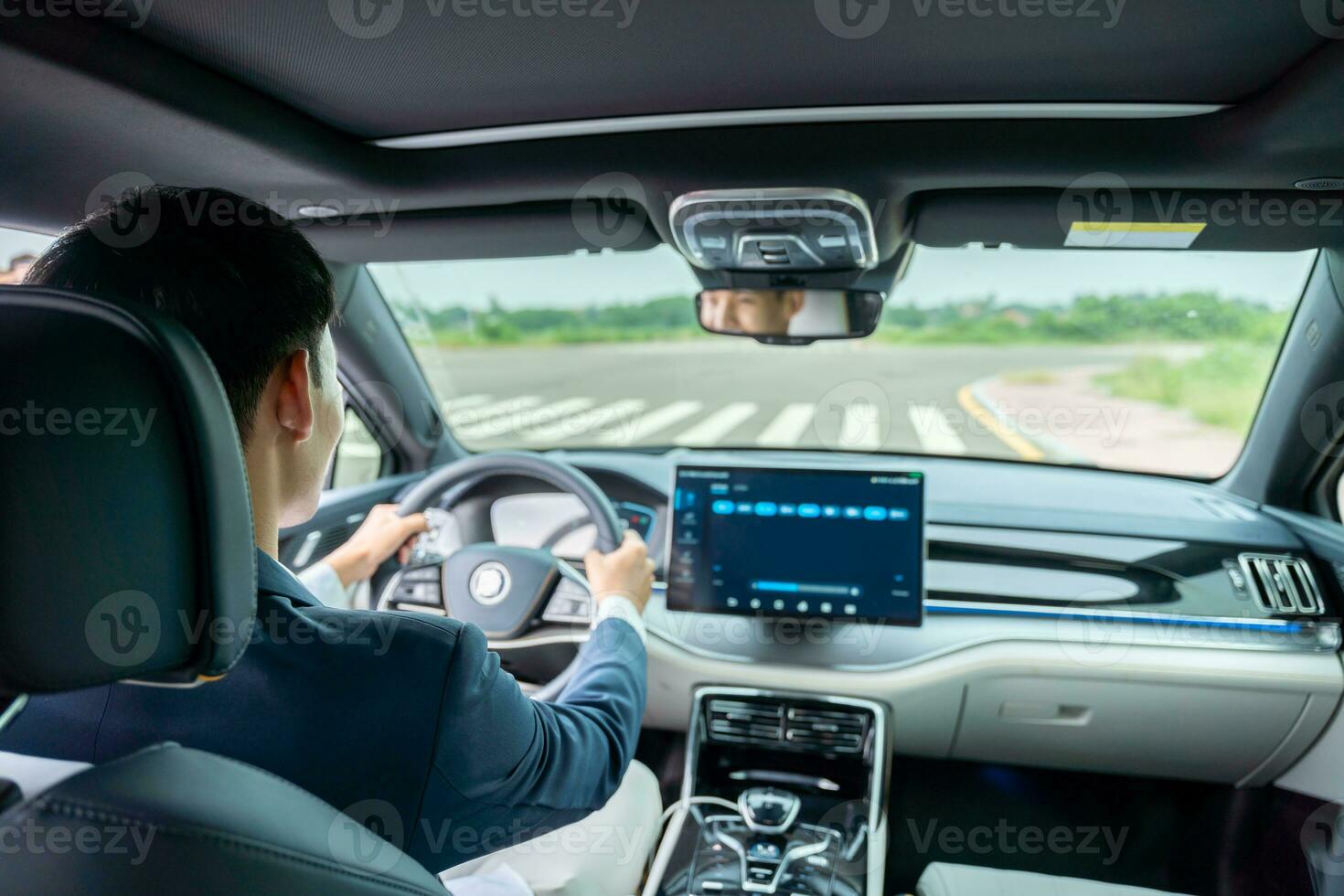 un hombre conducción dentro de eléctrico coche frente ver de el la carretera. eléctrico coche. ev coche. ev vehículo. foto