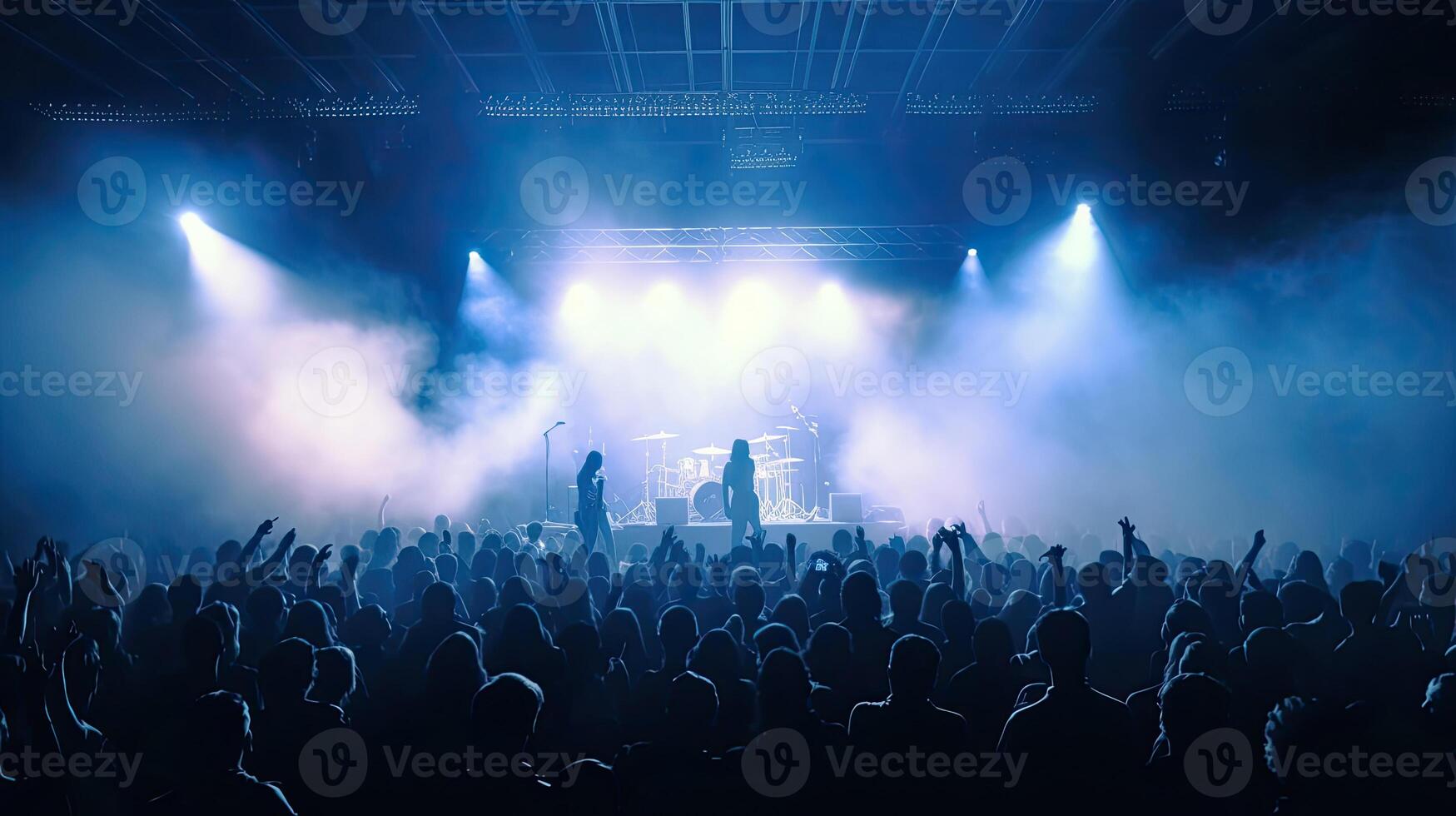 Silhouette of concert crowd in front of bright stage lights. Dark