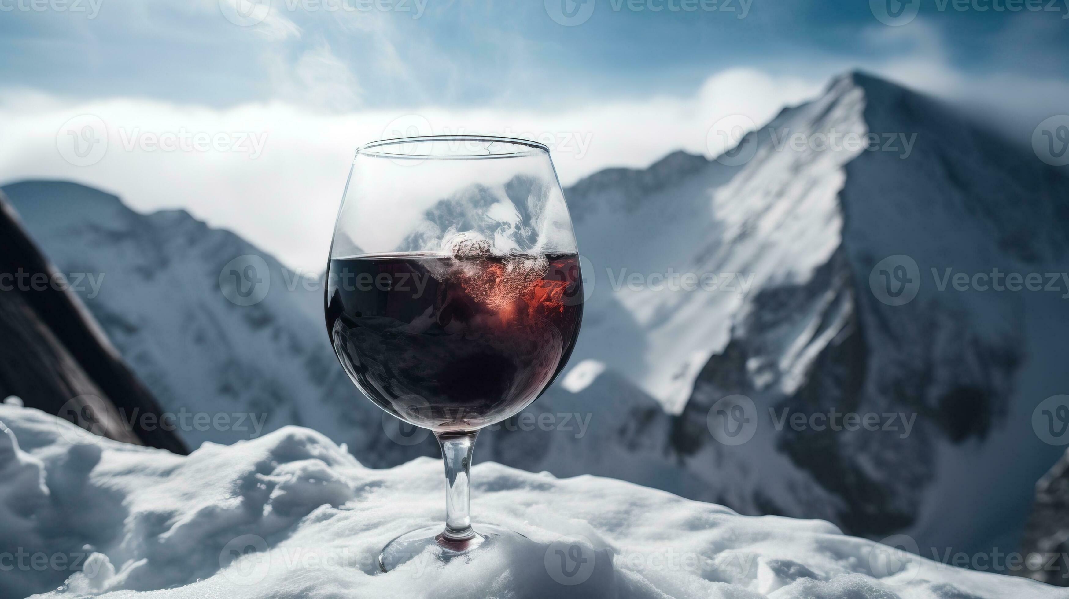 Glass of hot red wine closeup, background of snowcapped ski peaks of