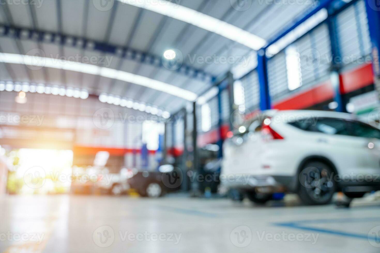 borroso de coche reparar estación pavimentado con epoxy piso y eléctrico levantar para un coche ese viene a cambio el motor petróleo en el antecedentes de mantenimiento coche Servicio centro. foto