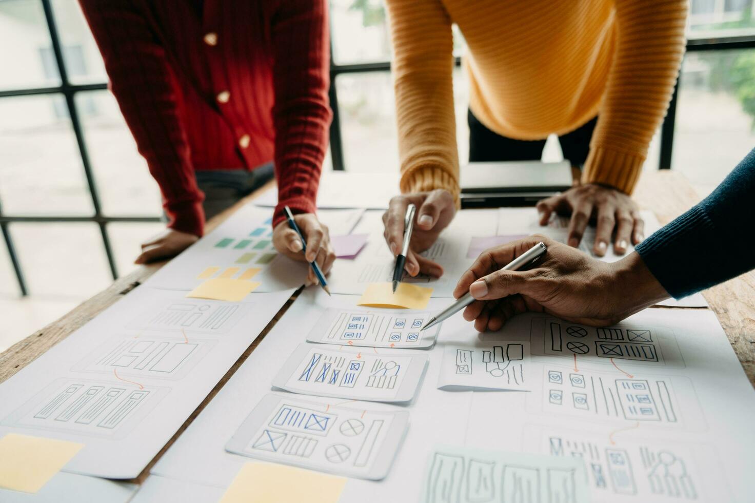 UX developer and ui designer brainstorming about mobile app interface wireframe design with customer breif and color code at modern office. photo