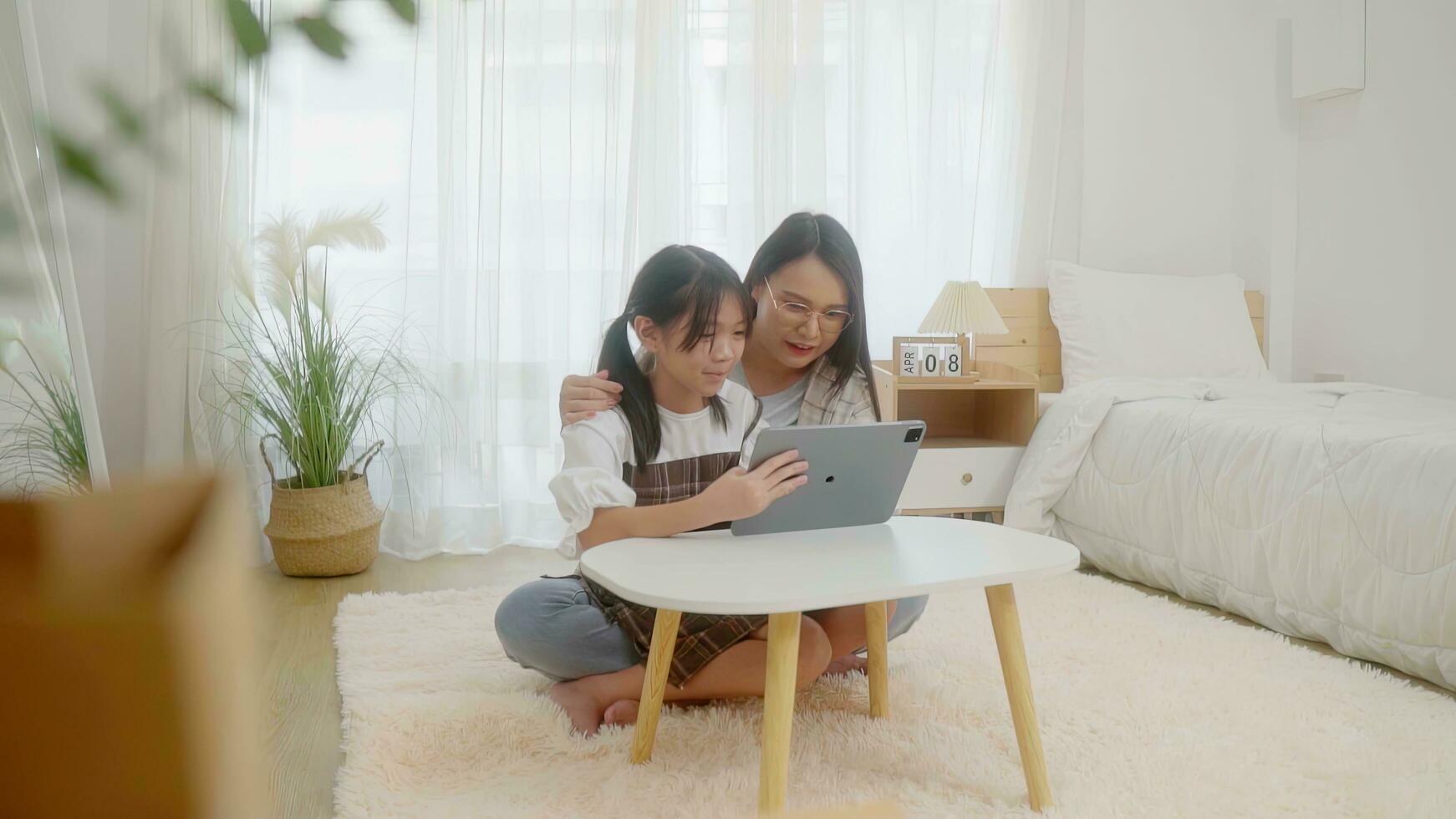 Asian little young girl learning online class at home with mother photo