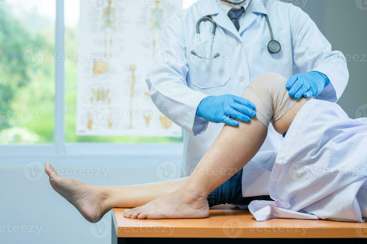 close-up hand wear medical gloves doctor examining head of patient with knee problems in clinic. photo