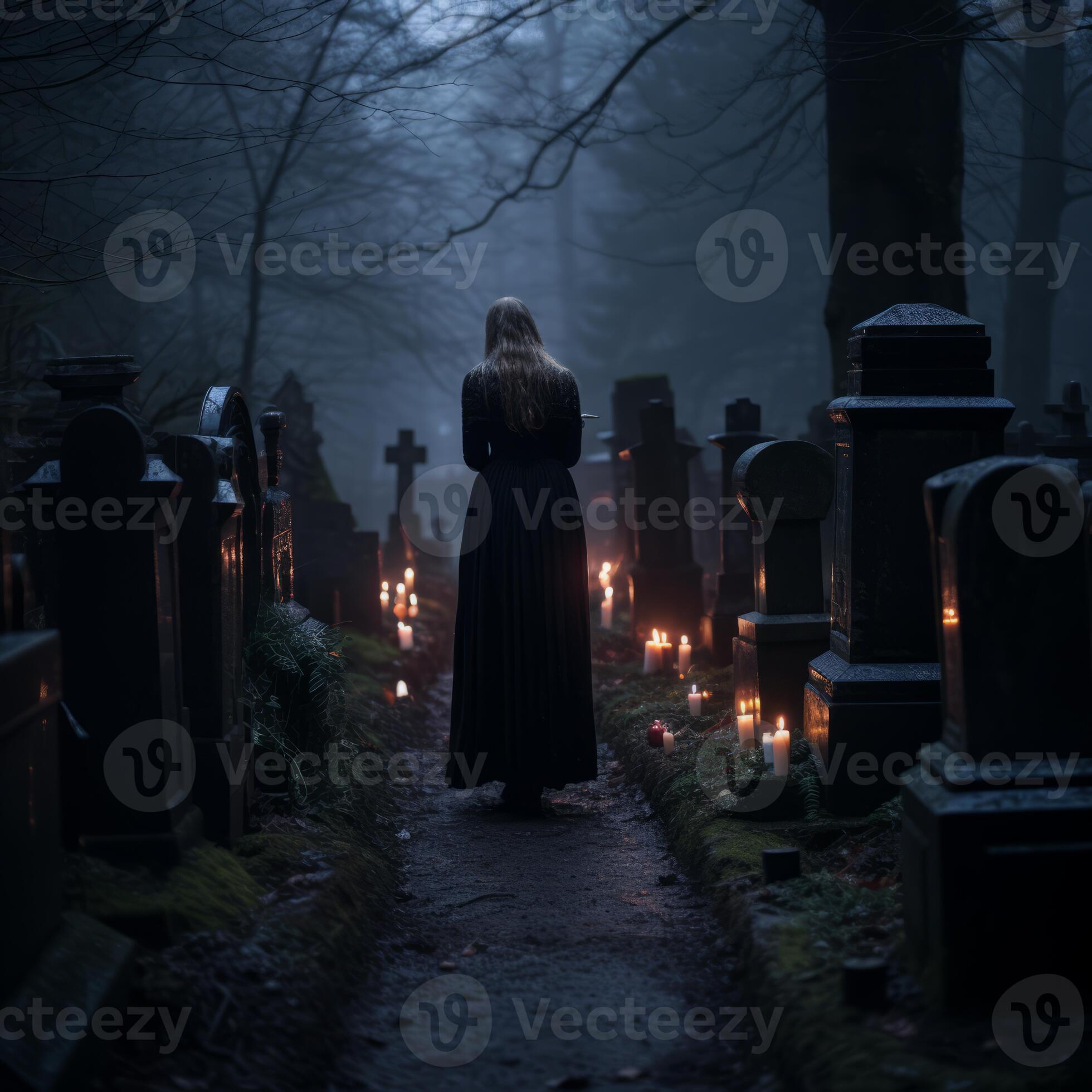 a woman in a long black dress walks through a cemetery at night