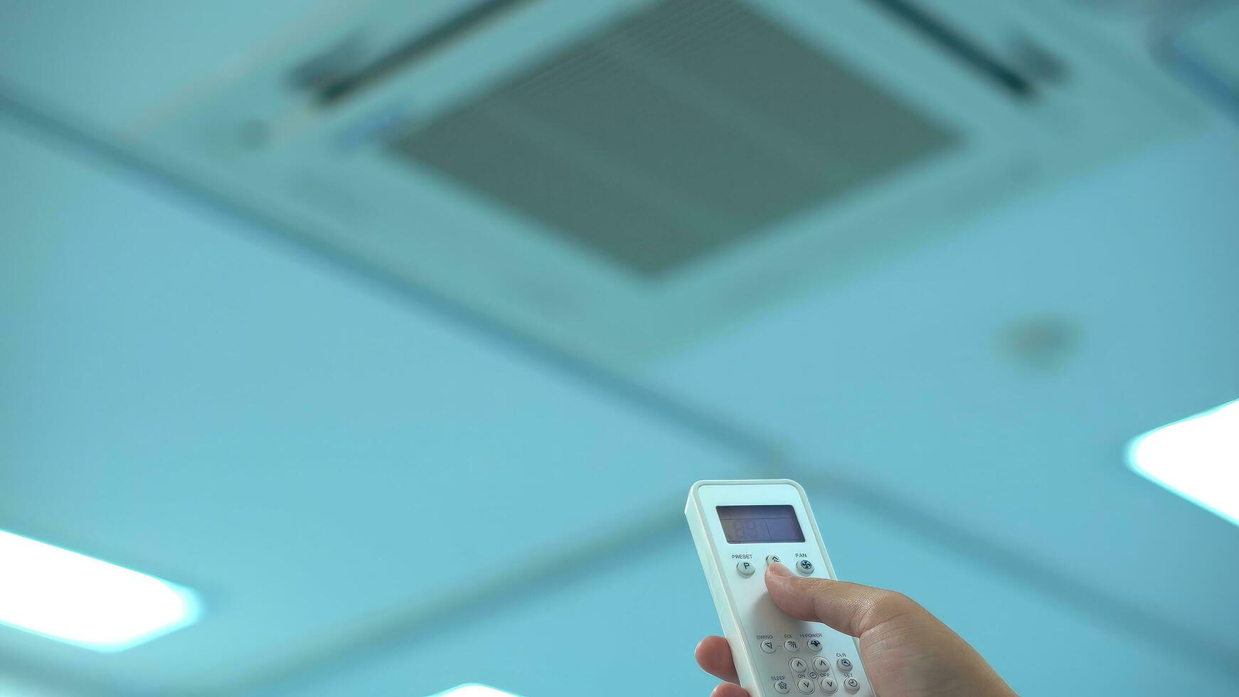 Hand with remote power on air conditioning split. photo