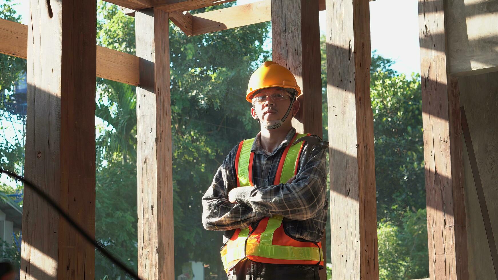 Carpenter young asia standing crossed arms smile in furniture factory. Happy young attractive carpenter wearing plaid shirt standing with crossed arms smiling and looking to camera. photo