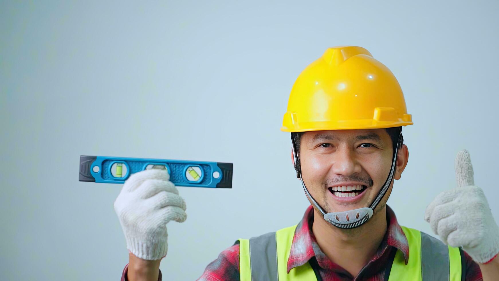 A young engineer wearing a yellow safety. using water level measuring ruler in empty copy space. photo