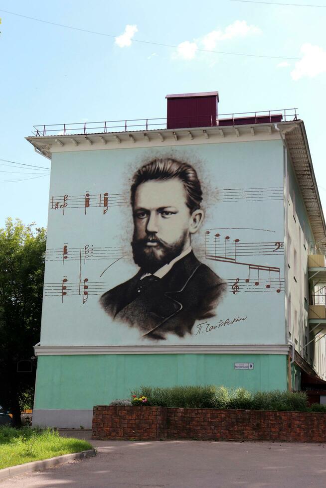 klin, Moscú, Rusia - 30.07.2023. pintada, un retrato de el ruso compositor piotr Ilich tchaikovsky con notas desde el ballet el cascanueces en el pared de un residencial edificio foto