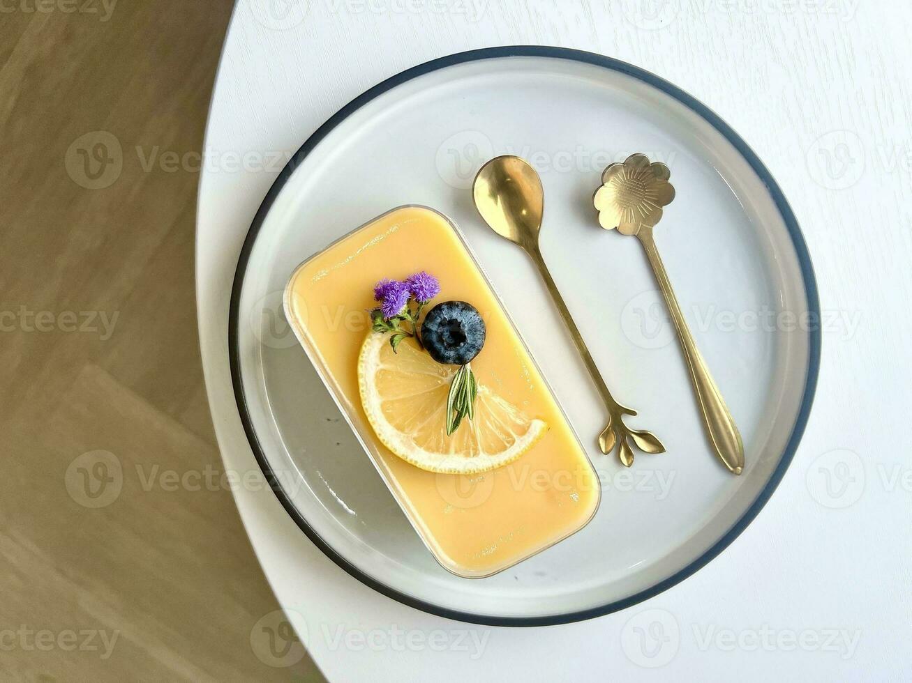 Lemon cheese tart dessert with fresh lemon and mint wildflowers on white wooden table photo