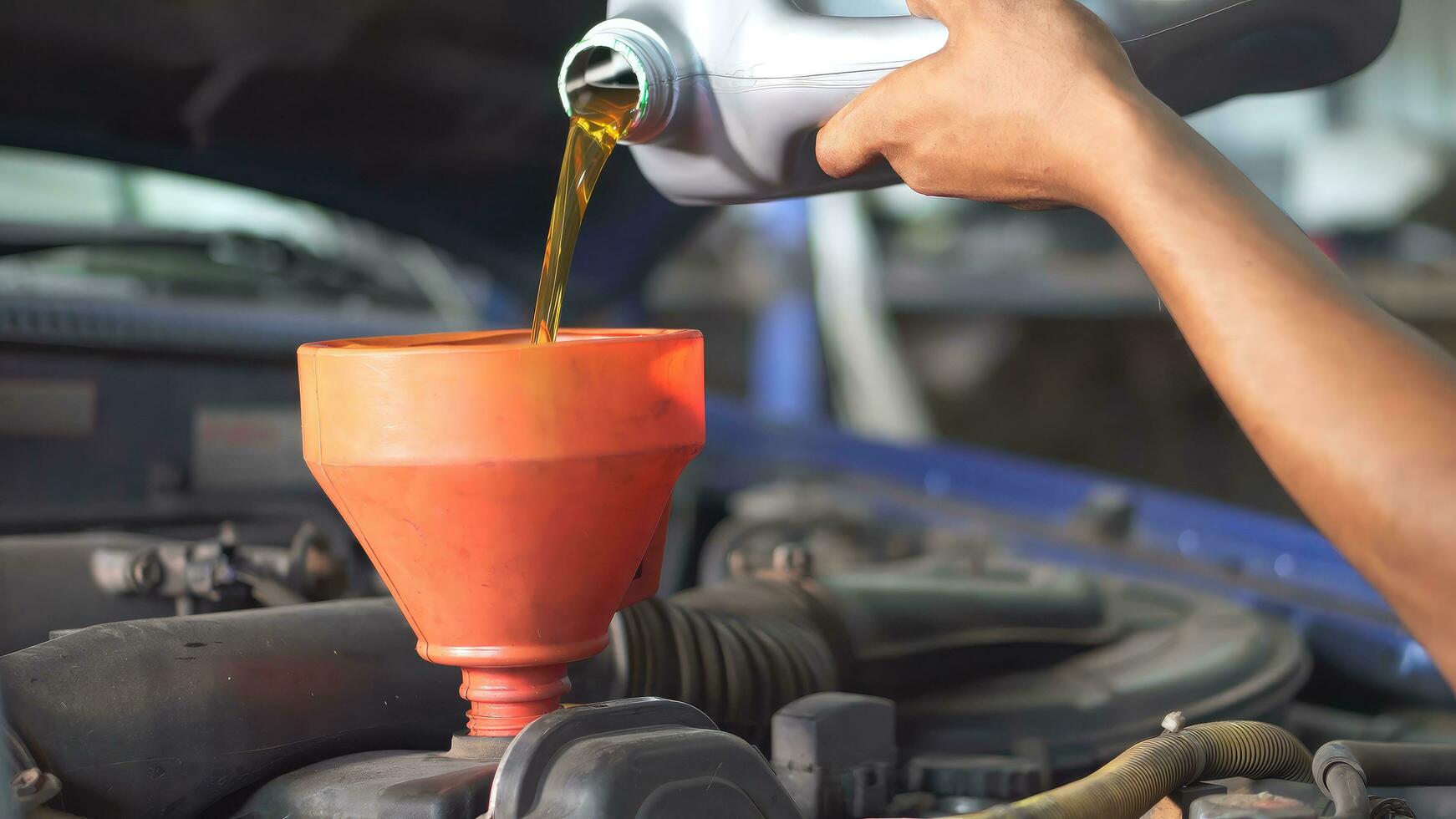 The mechanic is pouring new oil into the engine. Car technical fluid replacement. photo