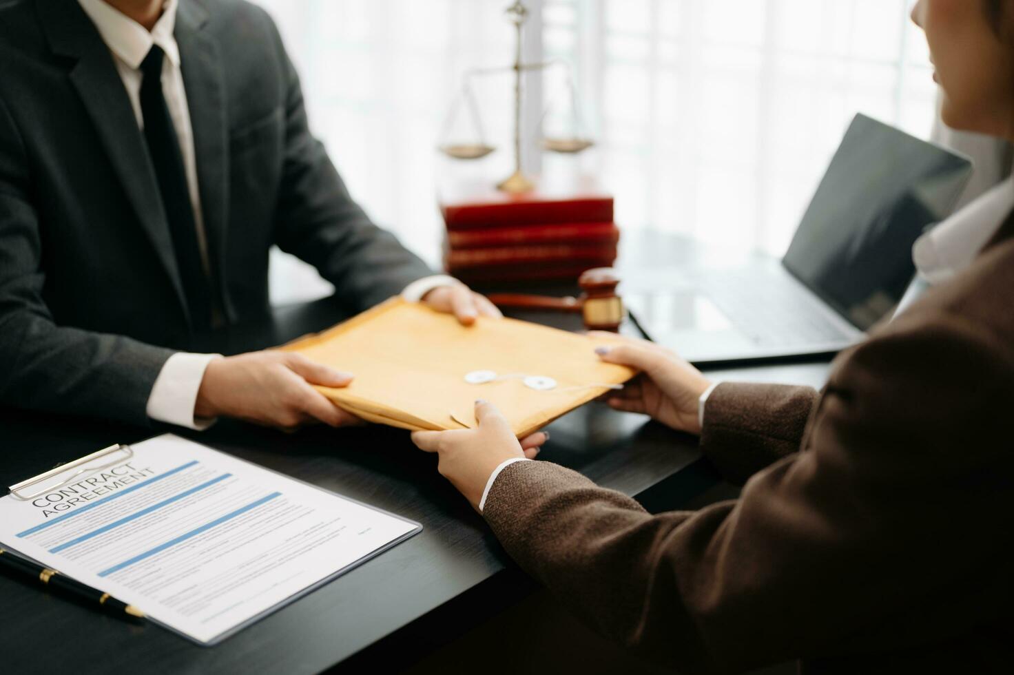 Business people compassionately holding hands and discussing contract papers with laptop and tabletat office photo