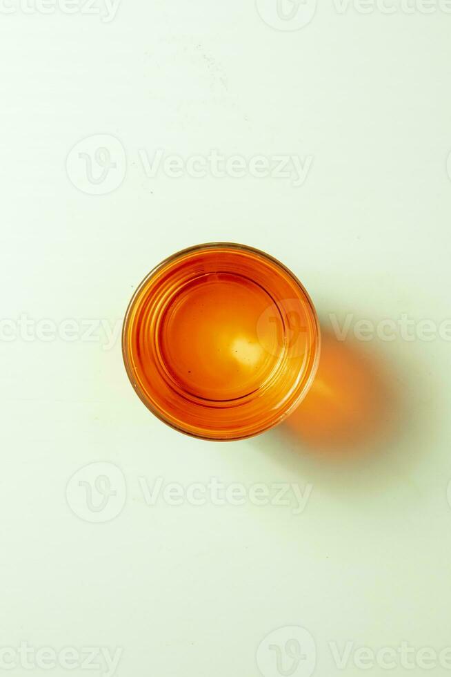 Orange glass on a white background. Flat lay. Top view. photo