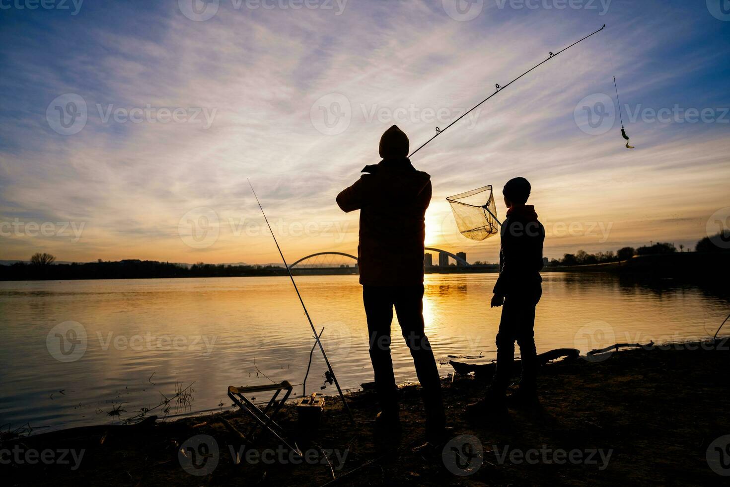 padre y hijo son pescar en invierno día. río pesca. foto