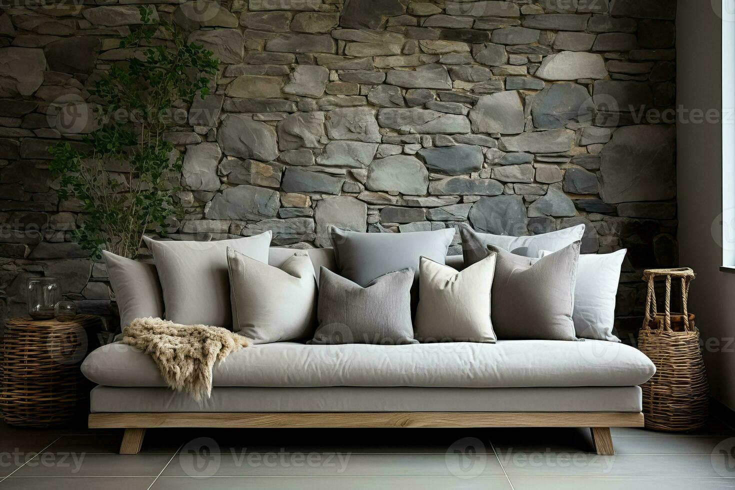 Light grey living room sofa with pillows in front of a natural stone wall photo
