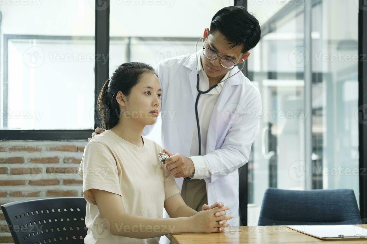 joven médico es utilizando un estetoscopio escucha a el latido del corazón de el paciente. foto