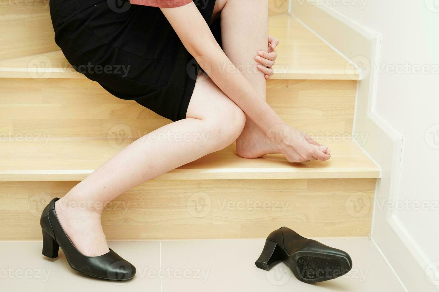 Asian business woman pain ankle, foot with leg cramp and fall down the stairs because slippery surfaces in office. photo