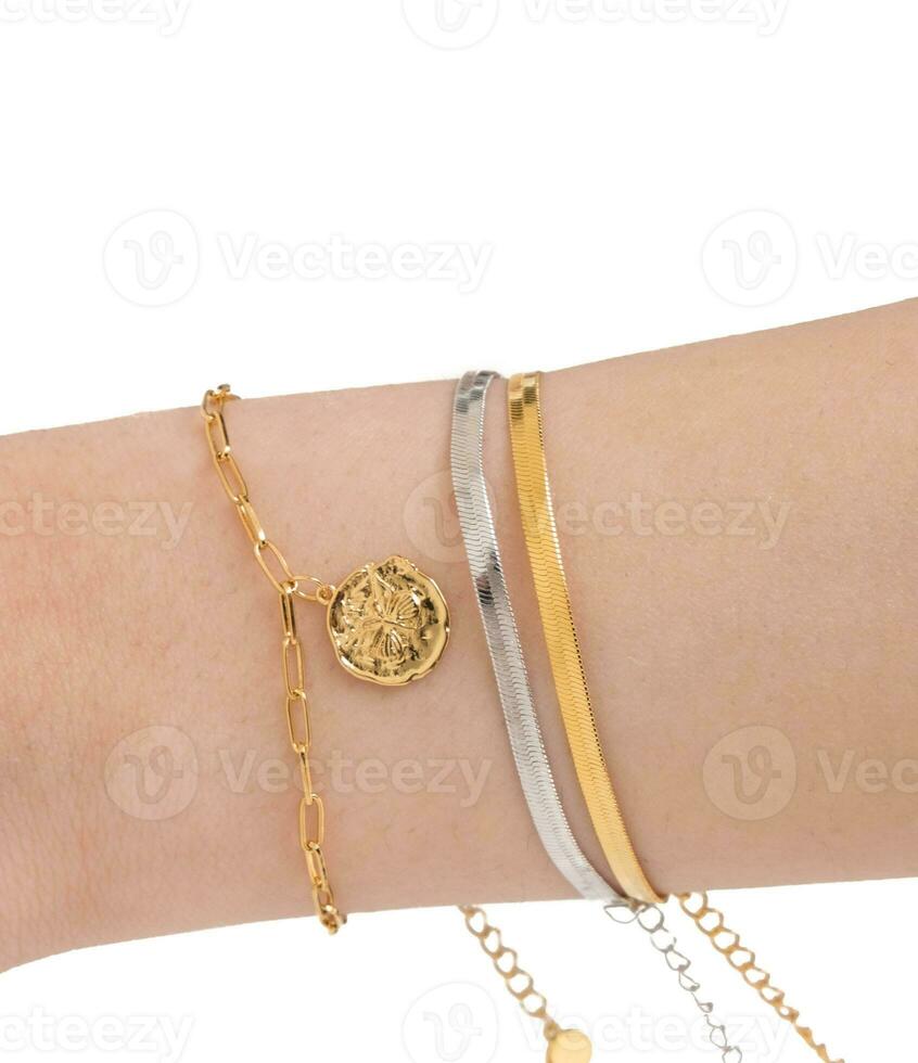 Woman wrist wearing golden butterfly and snake chain bracelets set against a white background.  Beautiful valentine's gift. photo