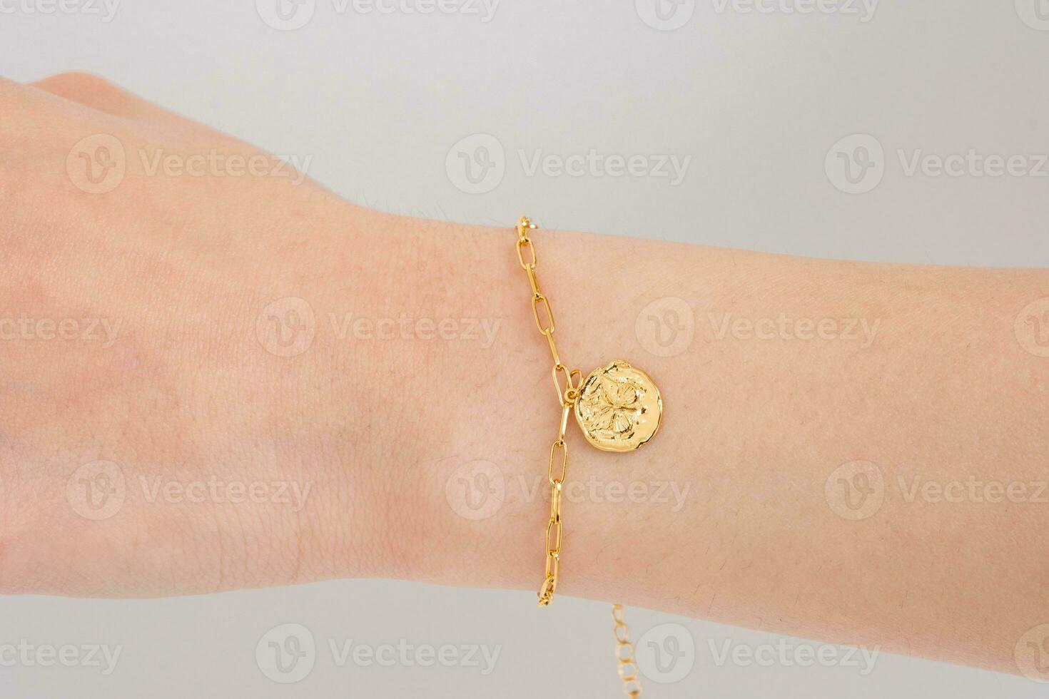 Woman wrist wearing golden butterfly bracelet set against a white background.  Beautiful valentine's gift. photo