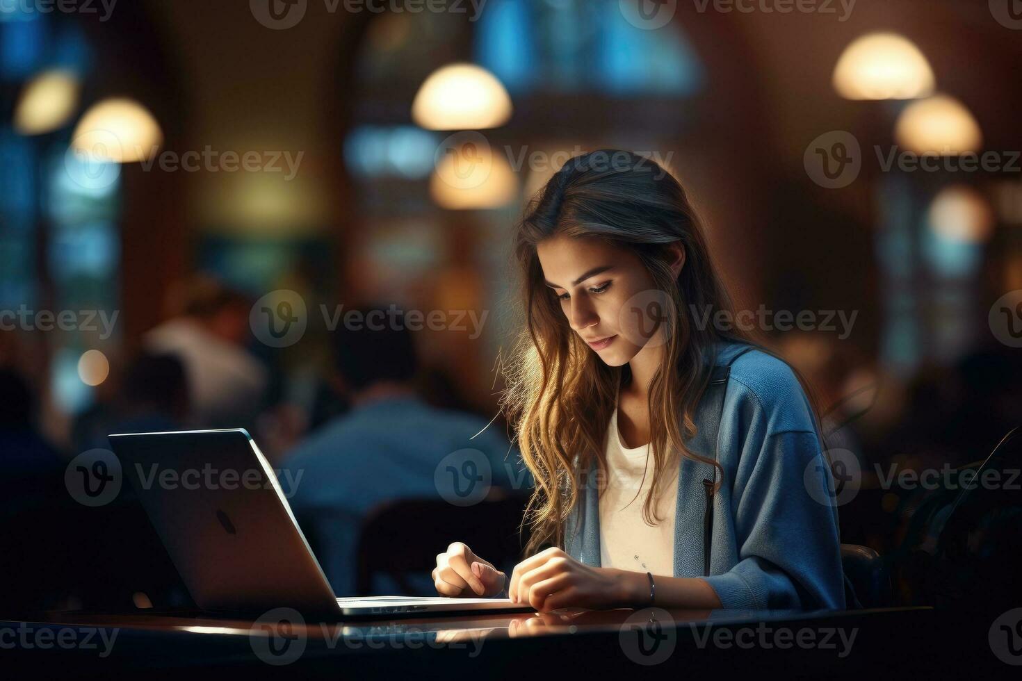 Confident woman working on laptop computer in library photo