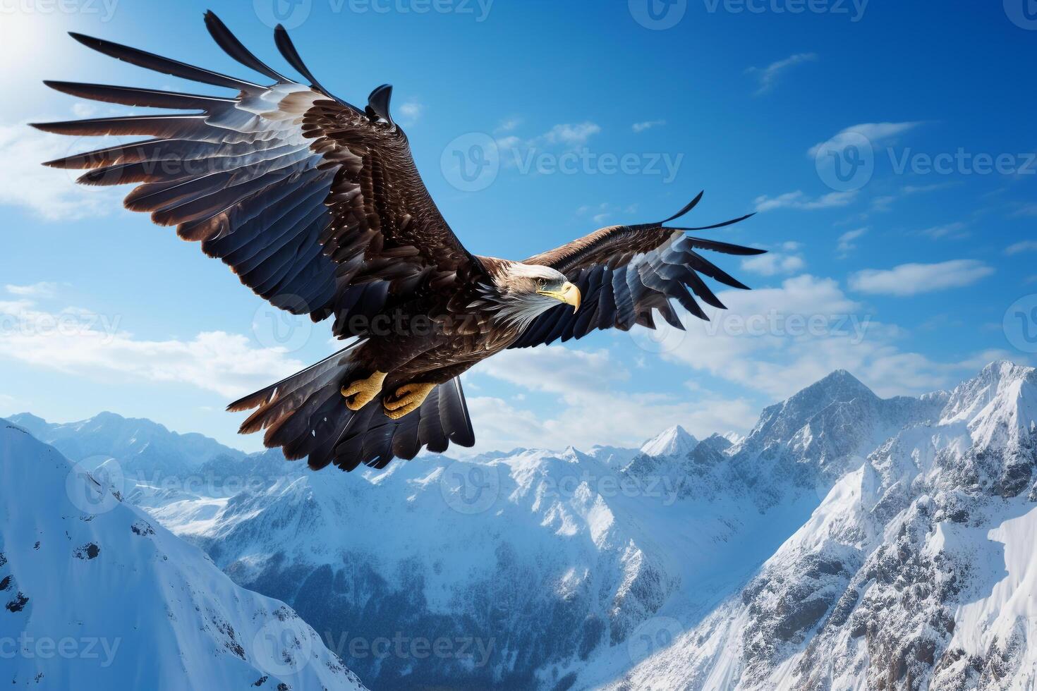 Majestic eagle soaring above a pristine, snow-capped mountain range under a blue sky photo