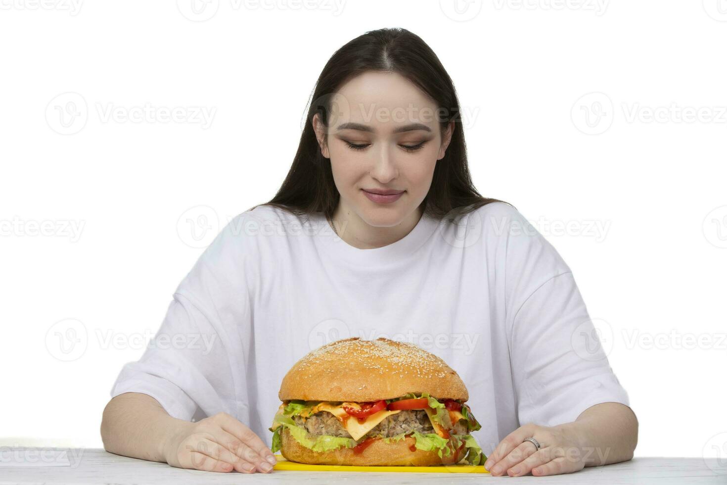 A woman is holding a big barbecue hamburger sandwich on the background. Fast food concept. The girl has a huge hamburger. photo