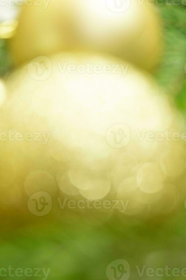 Defocused lights and blurred yellow-golden balls with green spruce with glowing background with soft focus. Merry Christmas and Happy New Year. Copy cpace photo