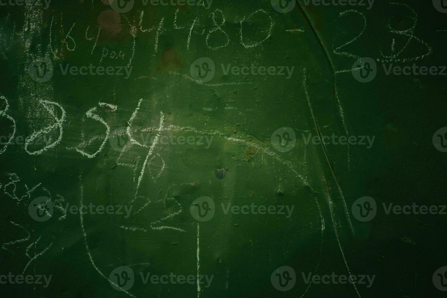 An old peeled green production board with numbers written in chalk. photo