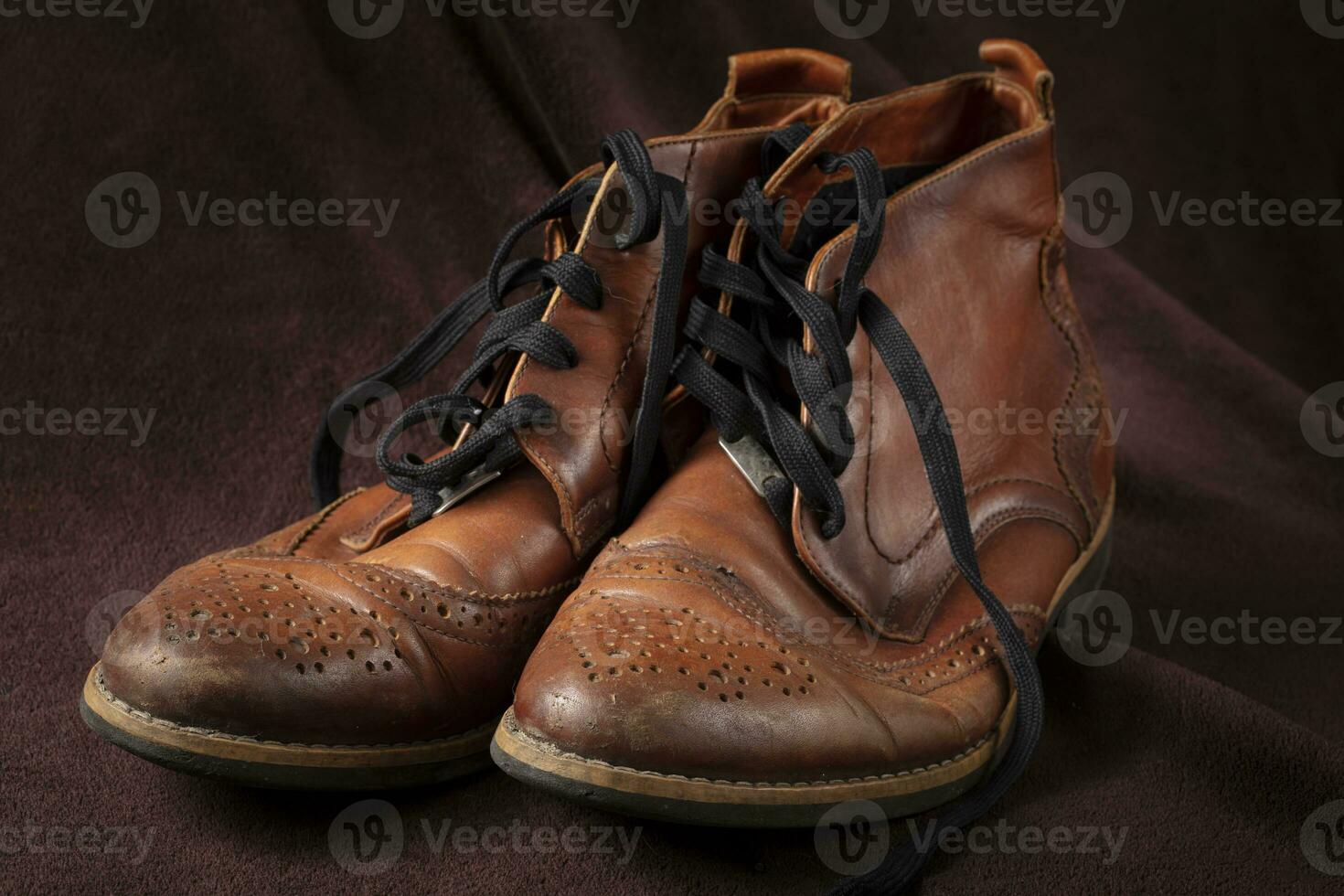 Old leather brown shoes on a dark background. photo