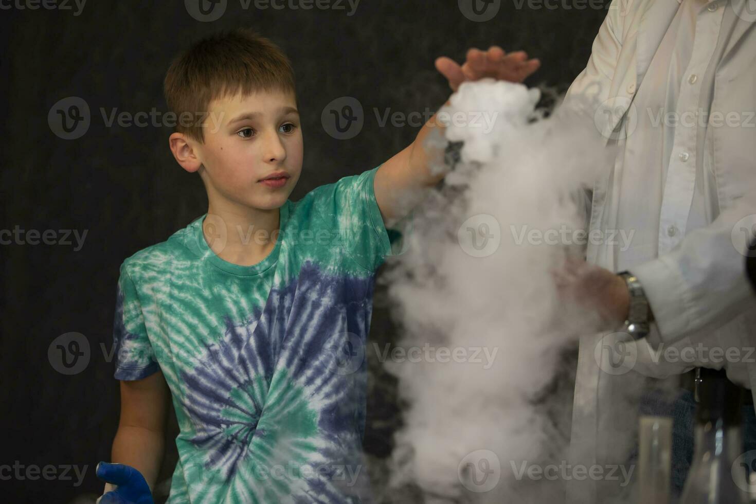 The boy conducts a scientific chemical experiment with liquid nitrogen. photo