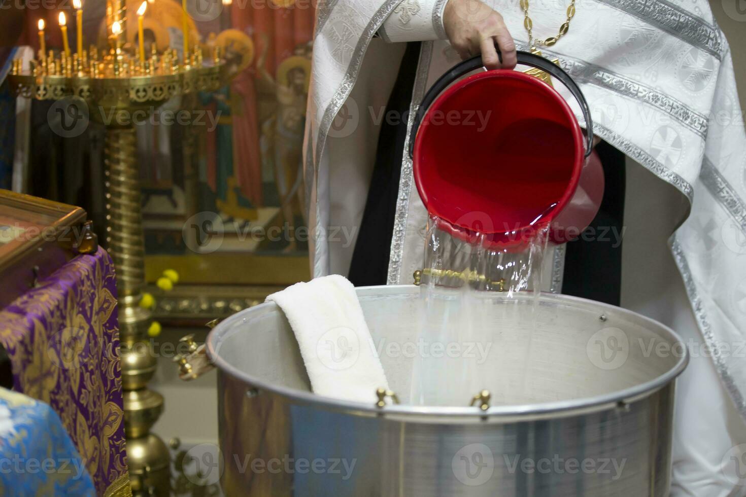 el rito de bautismo. sacerdote preparar a bautizar el niño. fuente para tomando fe.sacerdote vierte agua dentro el bañera para bautismo foto