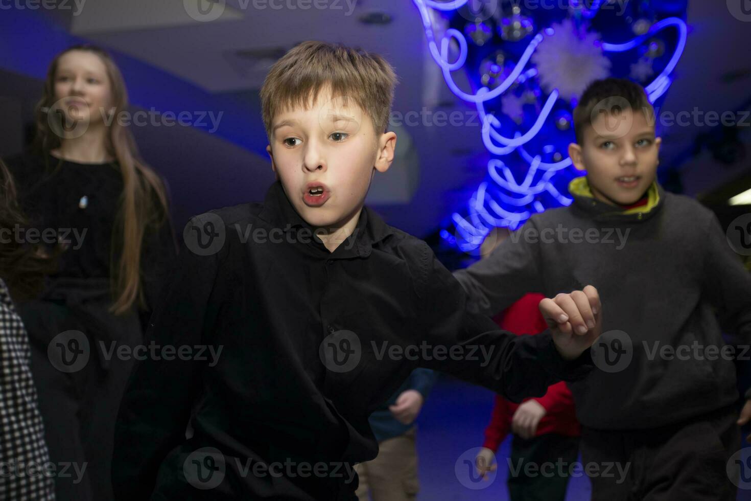 Happy kids dancing at a holiday party in the club, celebrating a birthday. photo