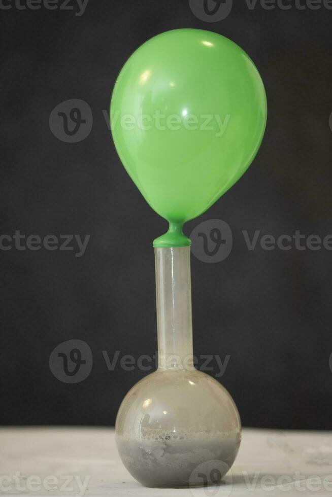 A rubber balloon is stretched over a chemical flask to demonstrate scientific experience. photo