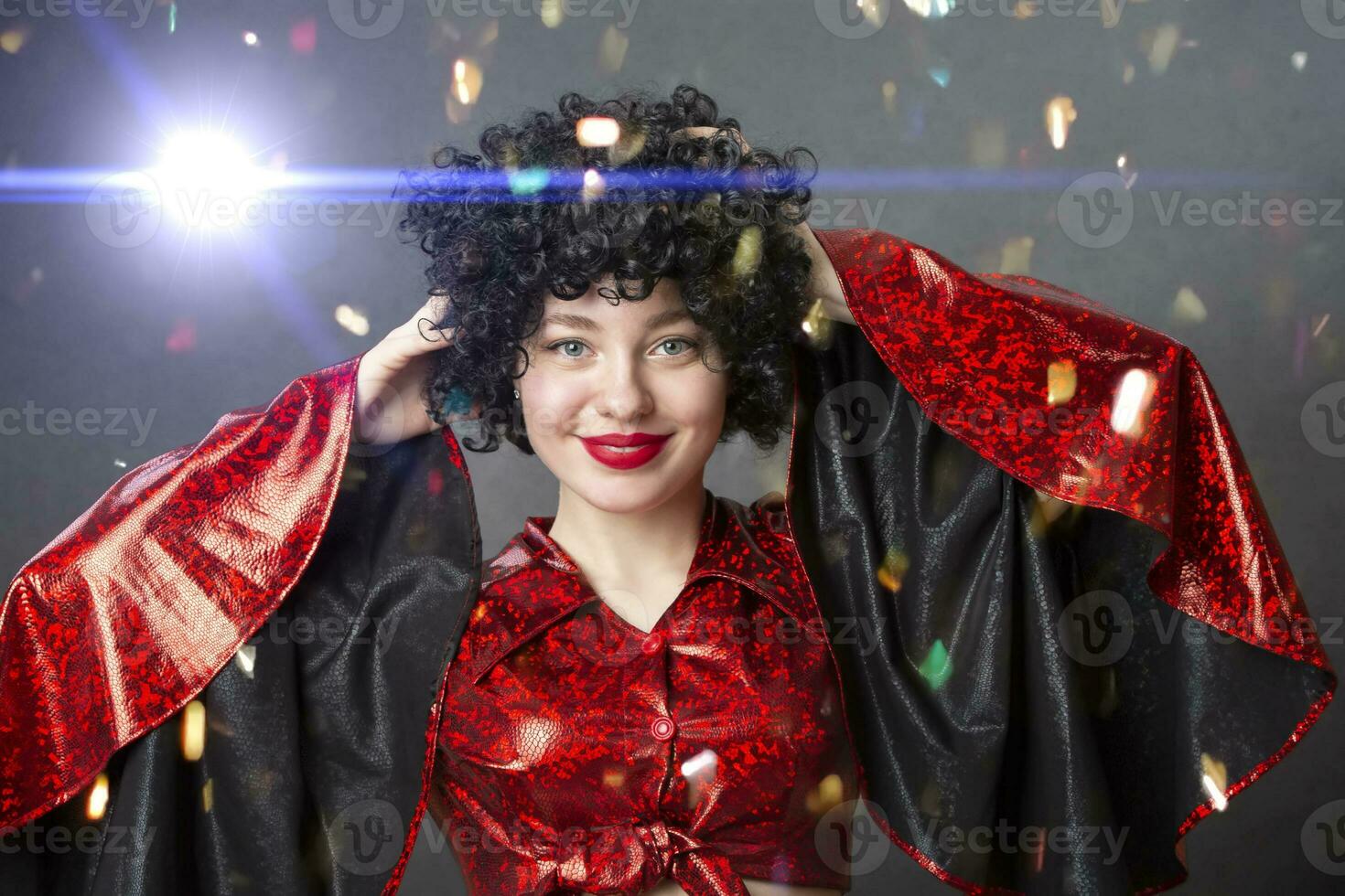 Festive smiling girl in an African American wig at a disco party. photo