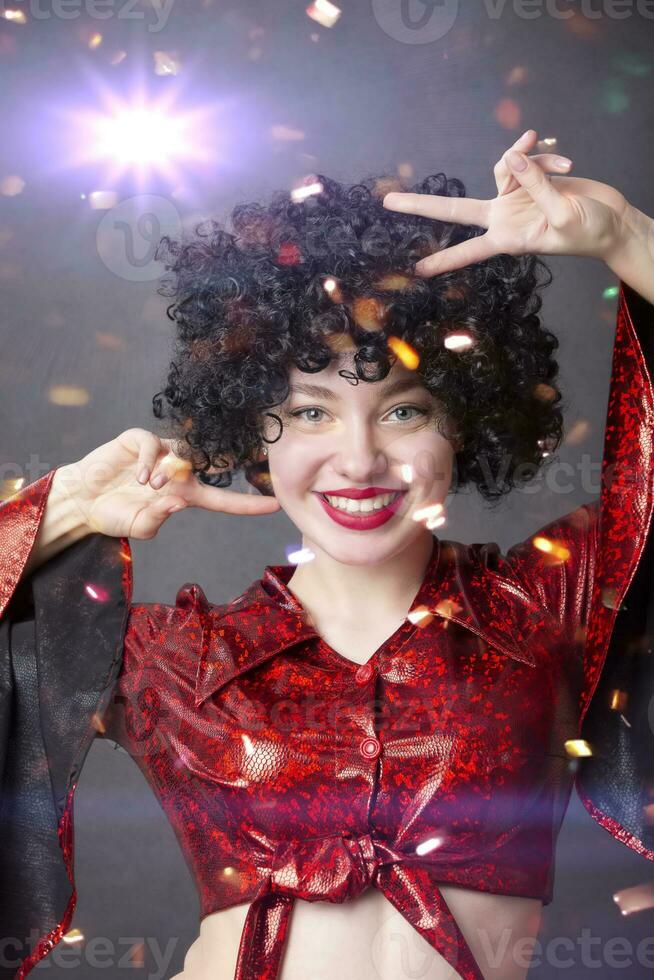 Festive smiling girl in an African American wig at a disco party. photo