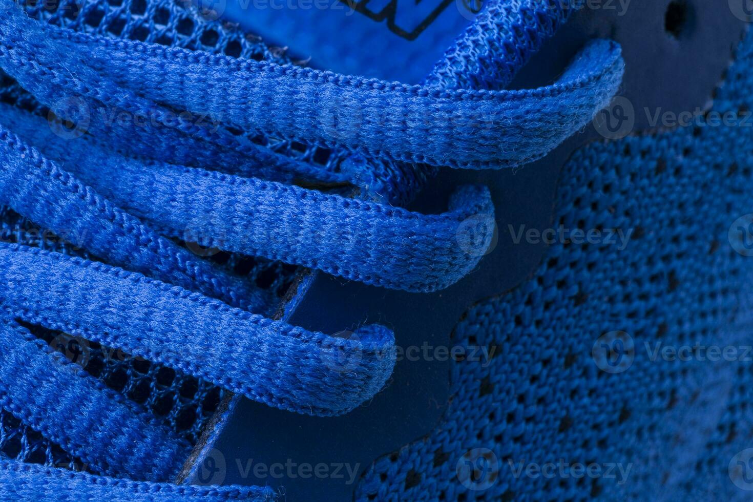 Fragment of a blue sneaker with drawstring macro.Sneaker texture photo