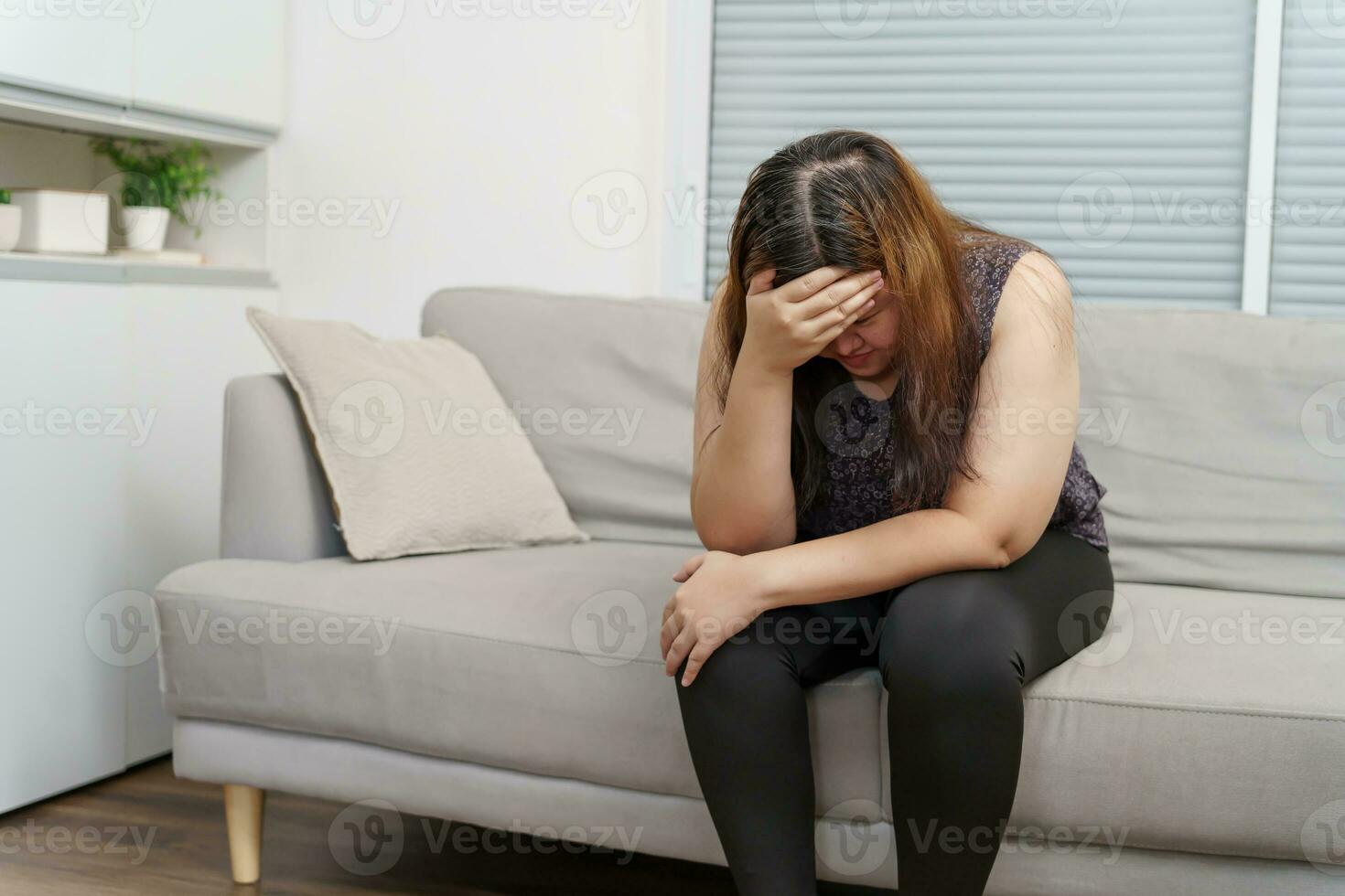 Sad Overweight plus size woman thinking about problems on sofa upset girl feeling lonely and sad from bad relationship or Depressed woman disorder mental health photo