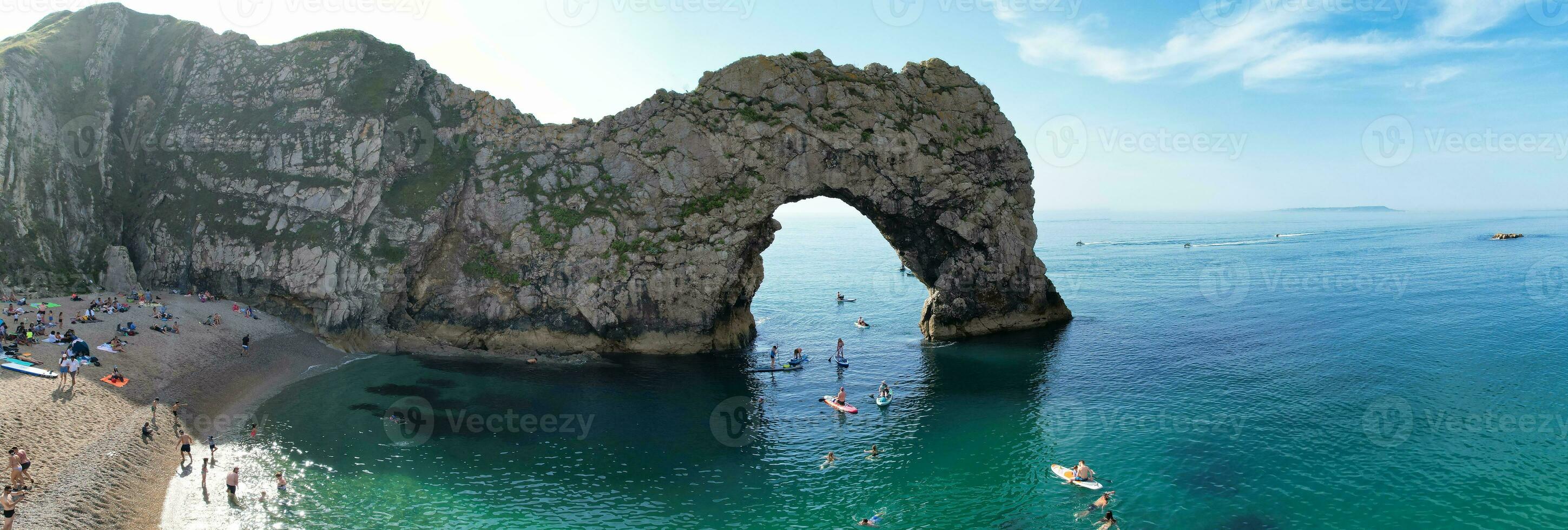 People at Most Beautiful High Angle View of British Landscape and Sea View of Durdle Door Beach of England Great Britain, UK. Image Was captured with Drone's camera on September 9th, 2023 photo