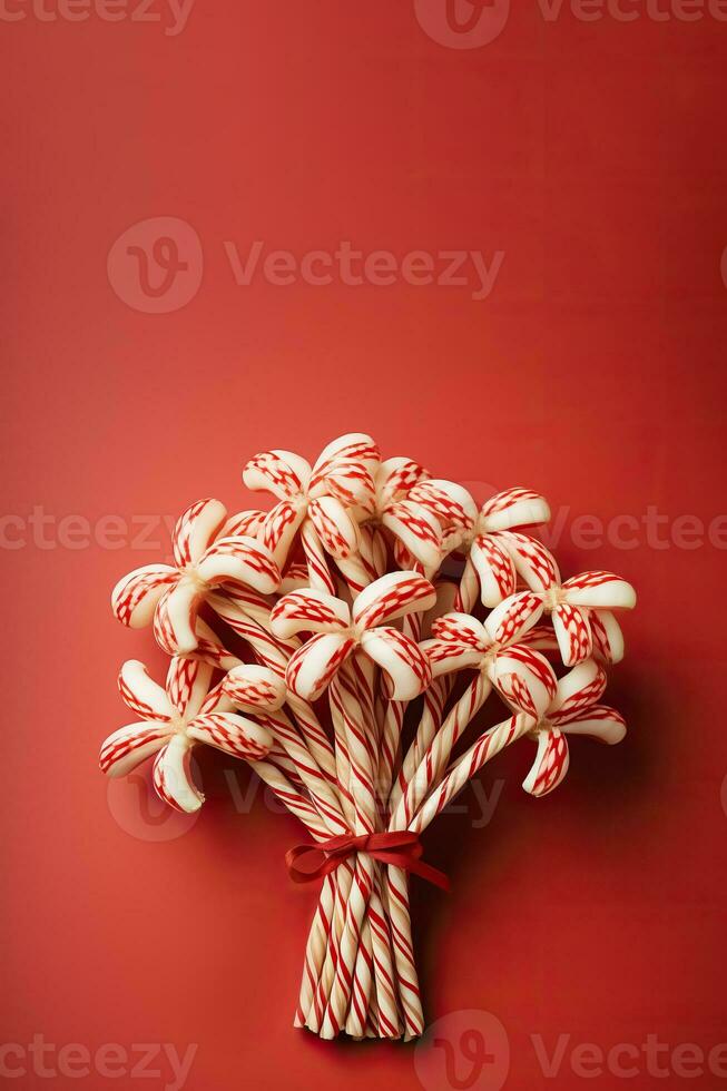 Bunch of antique candy canes adorned with rustic twine bows isolated on a candy-stripped red and white gradient background photo