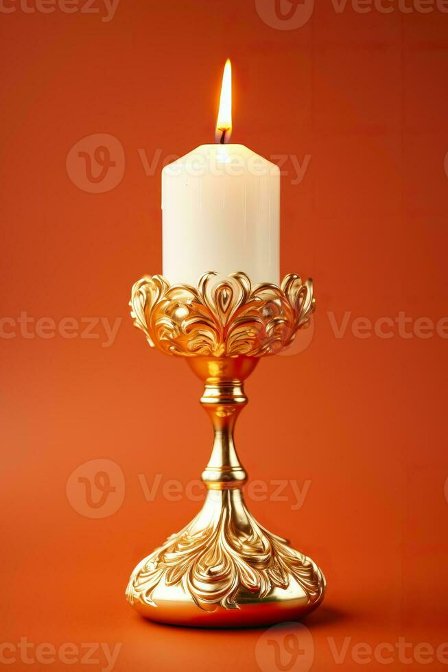 Golden mid-century candle holder with a glowing flame enhancing Christmas nostalgia isolated on a festive red gradient background photo