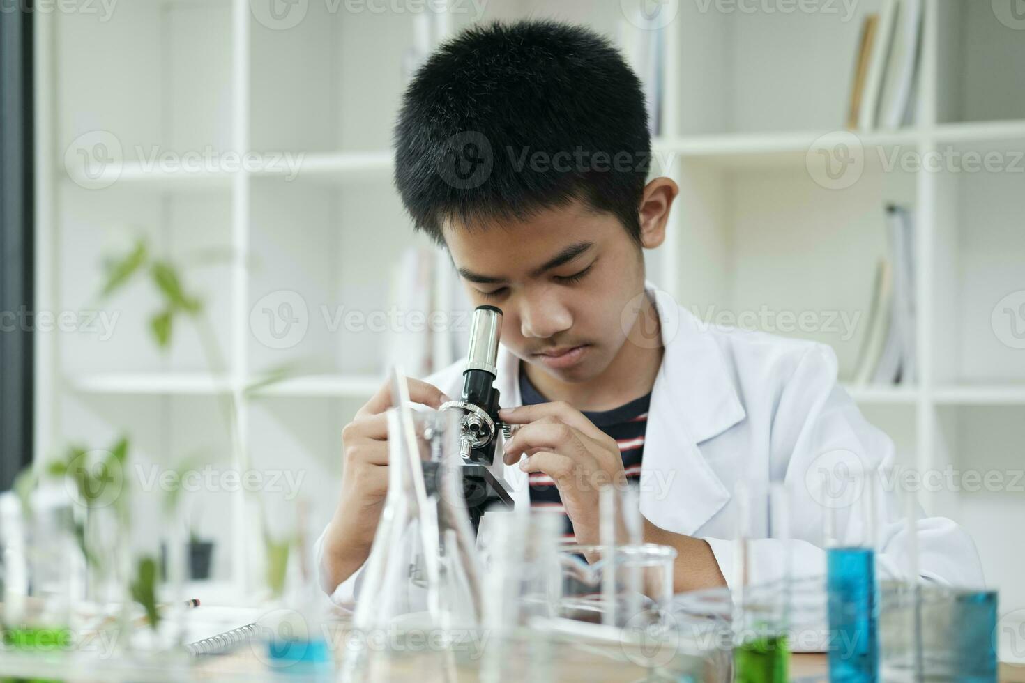 Young Scientist Elementary Schoolboy Explores with Microscope photo