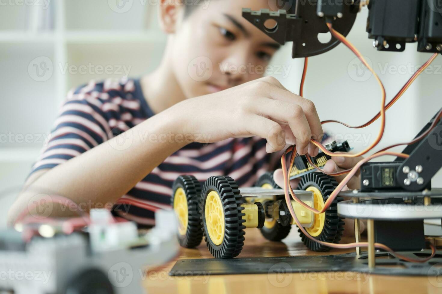 Asian teenager doing robot project in science classroom. technology of robotics programing and STEM education concept. photo