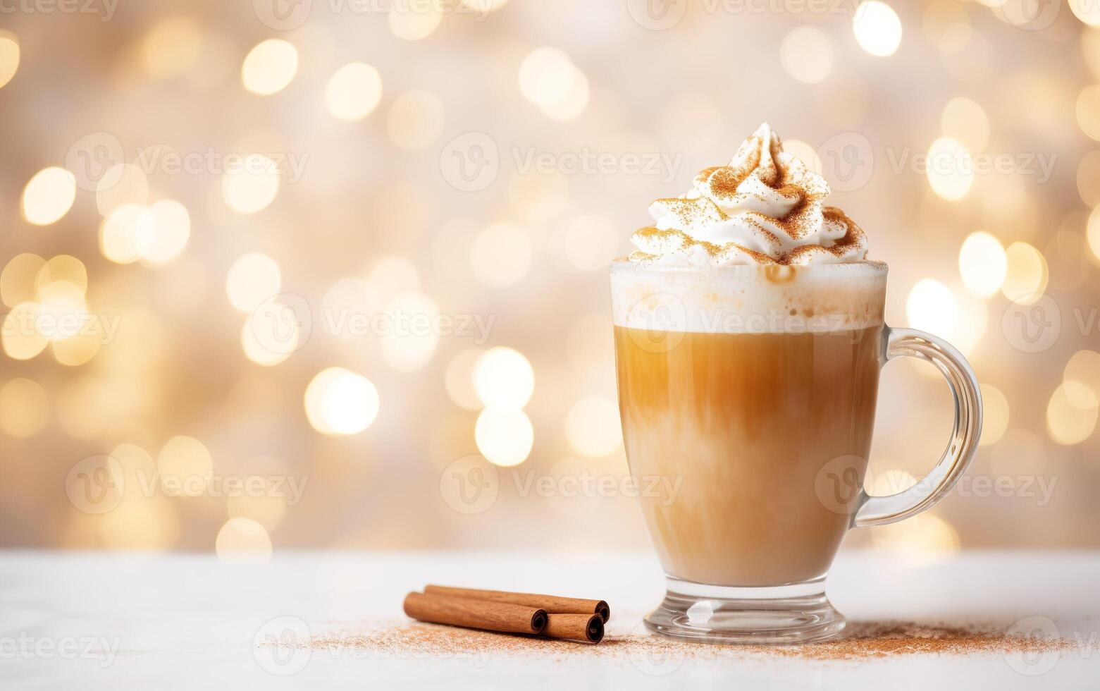 cup of latte with cinnamon and whipped cream, blurred, sparkling and fabulous white background with beautiful bokeh, light orange gold, festive atmosphere, cinnamon powder on the table. photo