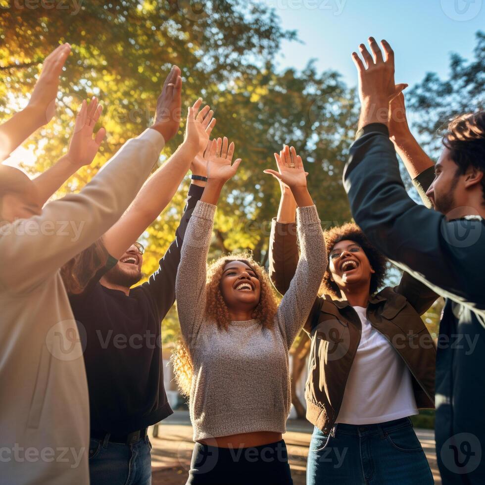 Celebratory high five moment among a diverse group of young people with vibrant background photo