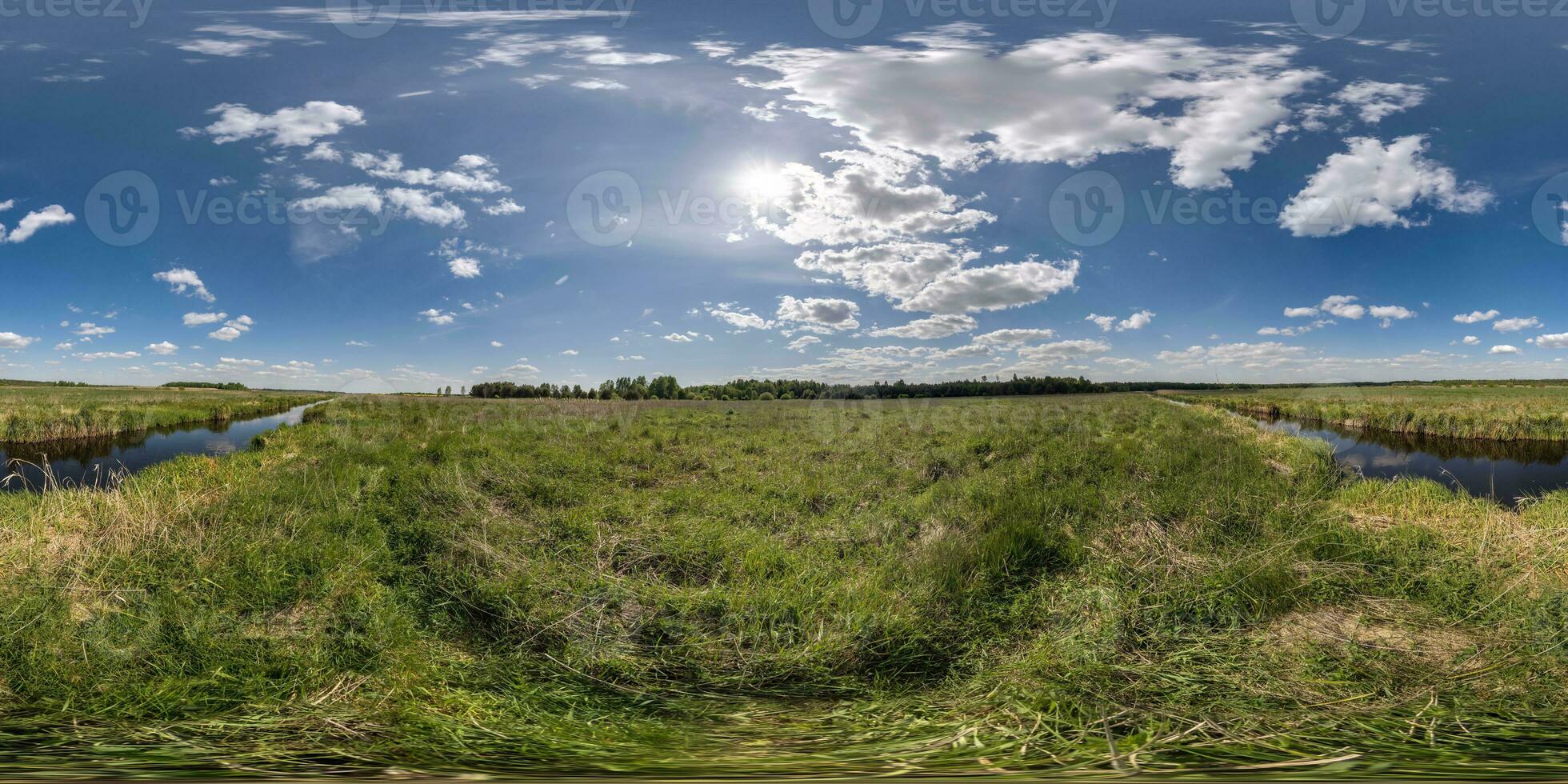 spherical 360 hdri panorama among green grass farming field near melioration reclamation canal in equirectangular seamless projection, as sky dome replacement, game development as skybox or VR content photo