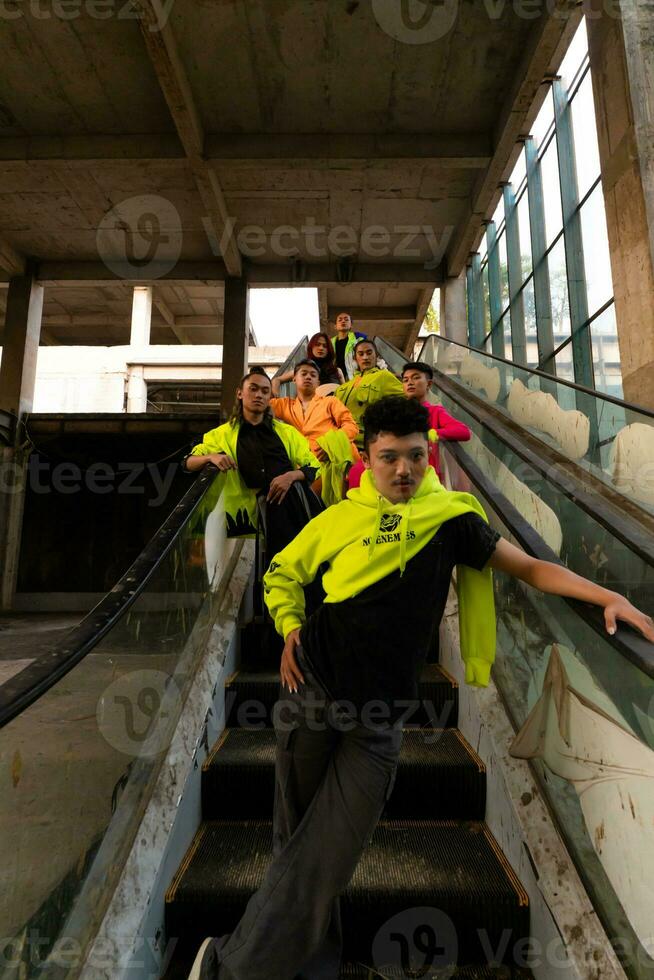 a group of Asian men in lemon green jackets are standing with their friends on the escalator photo